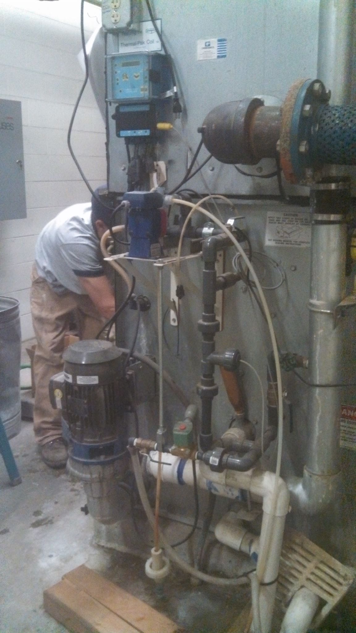 A technician from Eastern Oregon Heating and Air Conditioning LLC working on an HVAC unit in Hermiston, OR